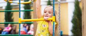 Young girl playing on playground equipment