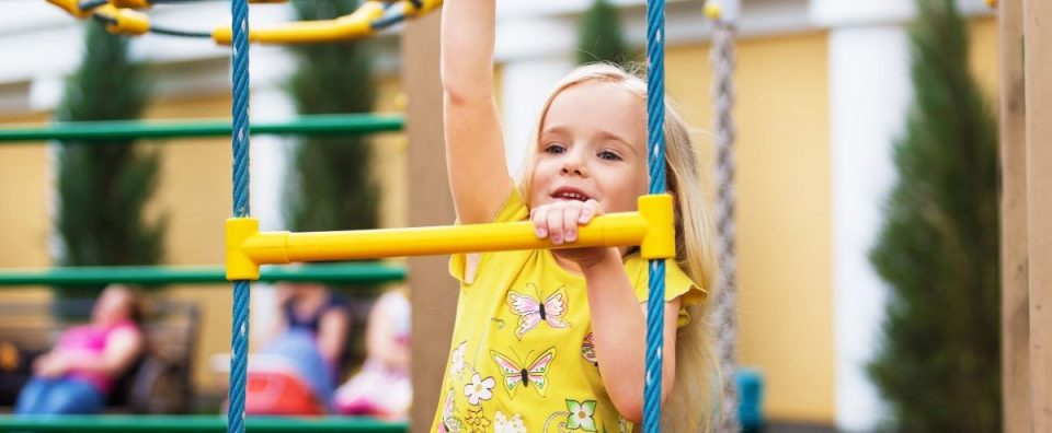 Young girl playing on playground equipment