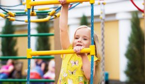 Young girl playing on playground equipment