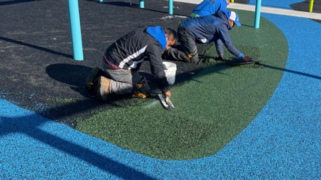 two contractors installing new pour in place rubber surfacing